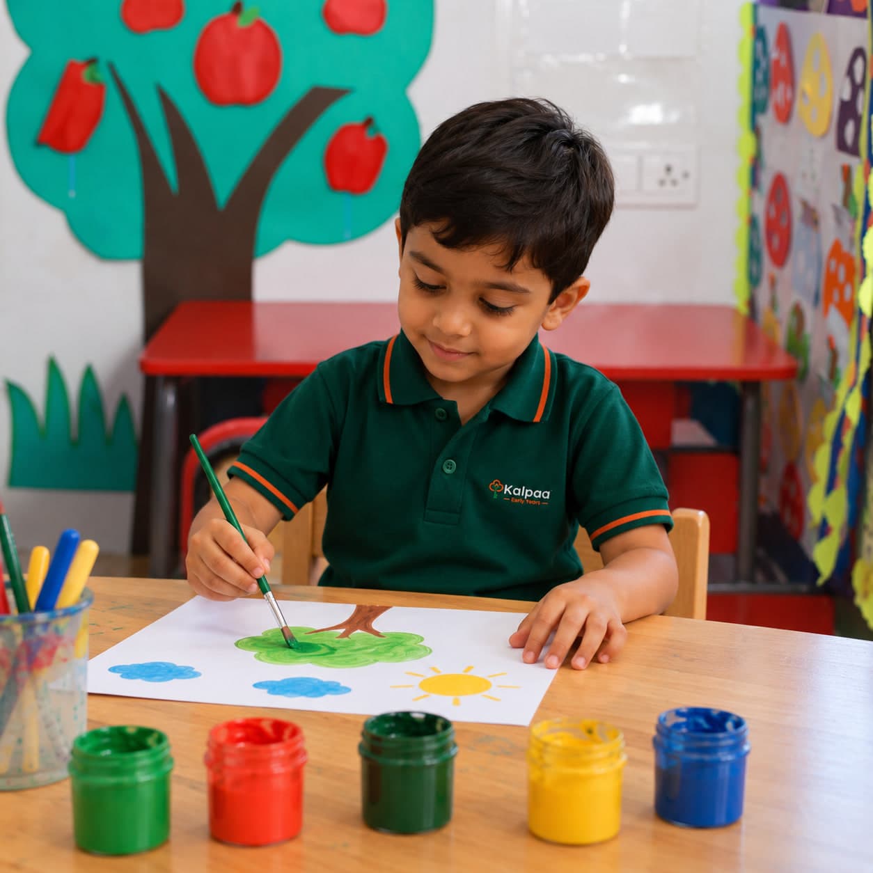 A Kalpaa child painting a tree at the atelier table