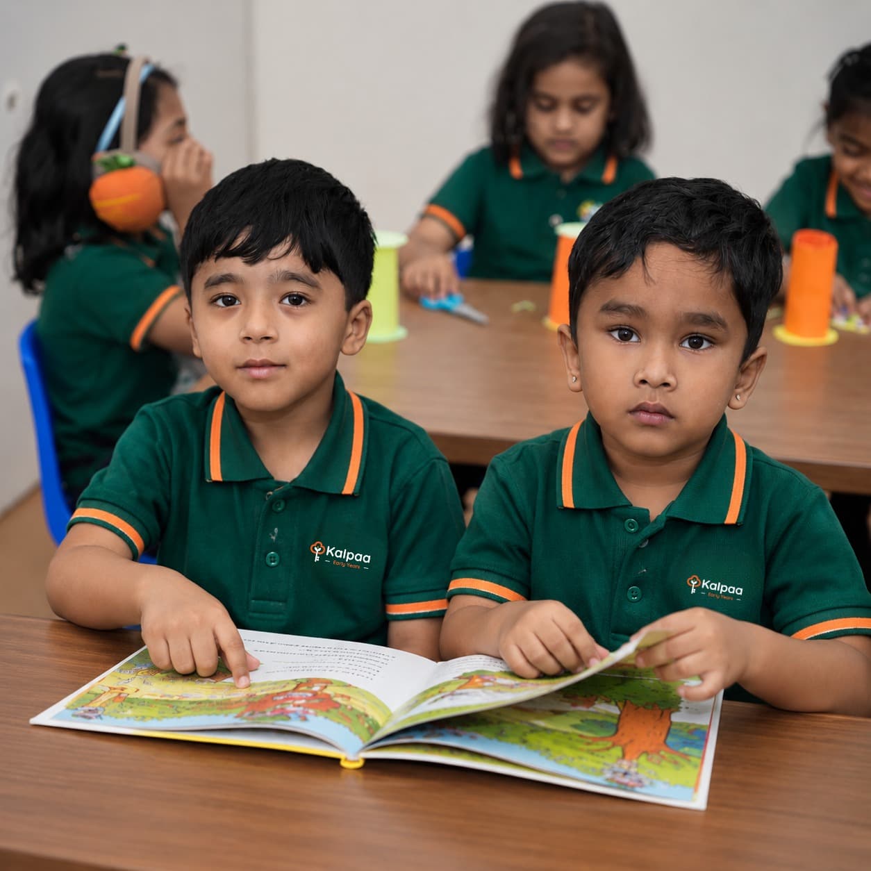 Two Kalpaa boys sharing a picture book at their table